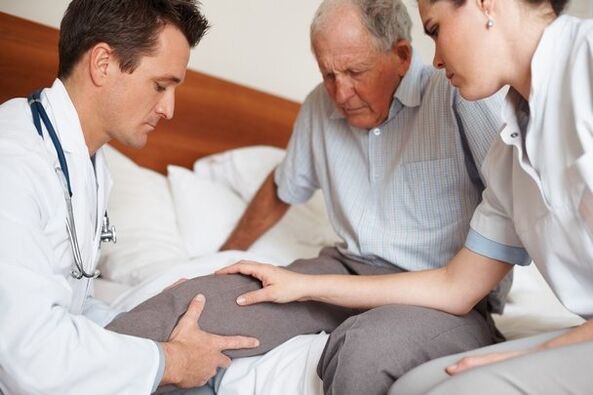 Médecin examinant le genou du patient